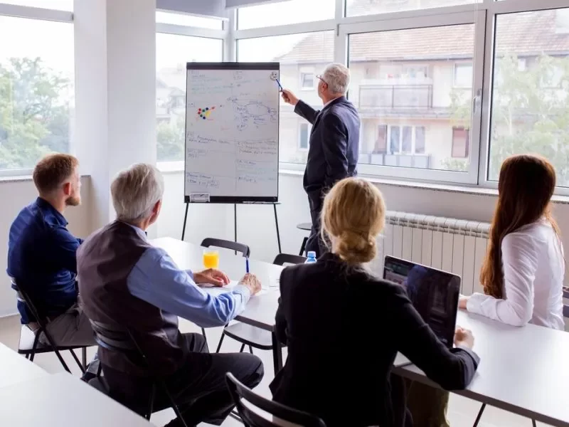 senior-businessman-giving-presentation-colleagues-office_23-2147923329-qx16z39mmjwaewhfqgl0m6p9kbssjh7jtou40peyk0